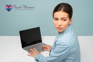 woman sitting at a computer, looking away, distracted | Purple Horizons